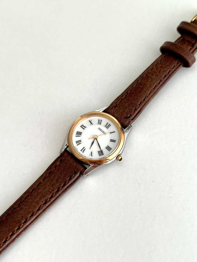 Seiko Exceline gold tone round bezel, silver tone tapered lugs and brown stitched leather strap
