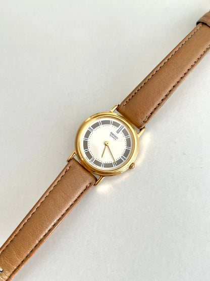 Seiko gold tone watch with an ivory centre, segmented grey dial and tan leather strap, front view