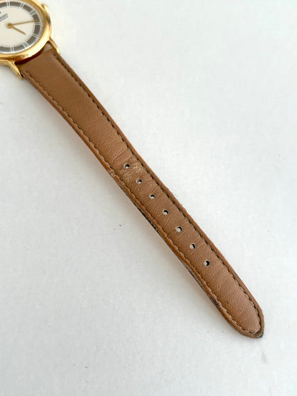 Tan leather strap adjustment holes and tonal edge stitching