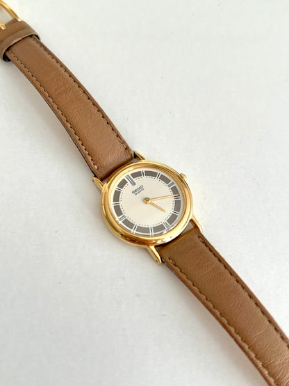 Close view of the Seiko ivory dial with grey outer panels, pale Roman markers and two gold tone hands