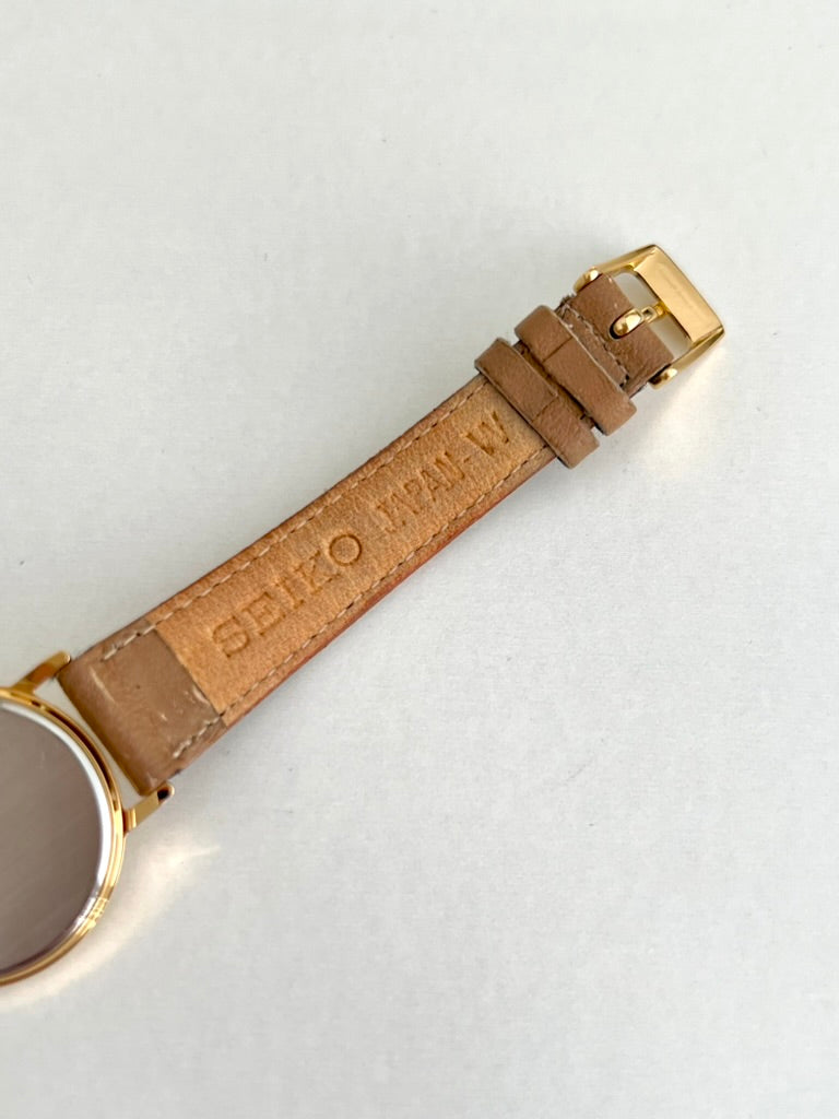 Seiko signature on the underside of the tan leather strap with its pin buckle