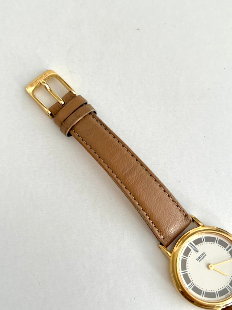 Stitched tan leather strap and gold tone pin buckle on the Seiko watch