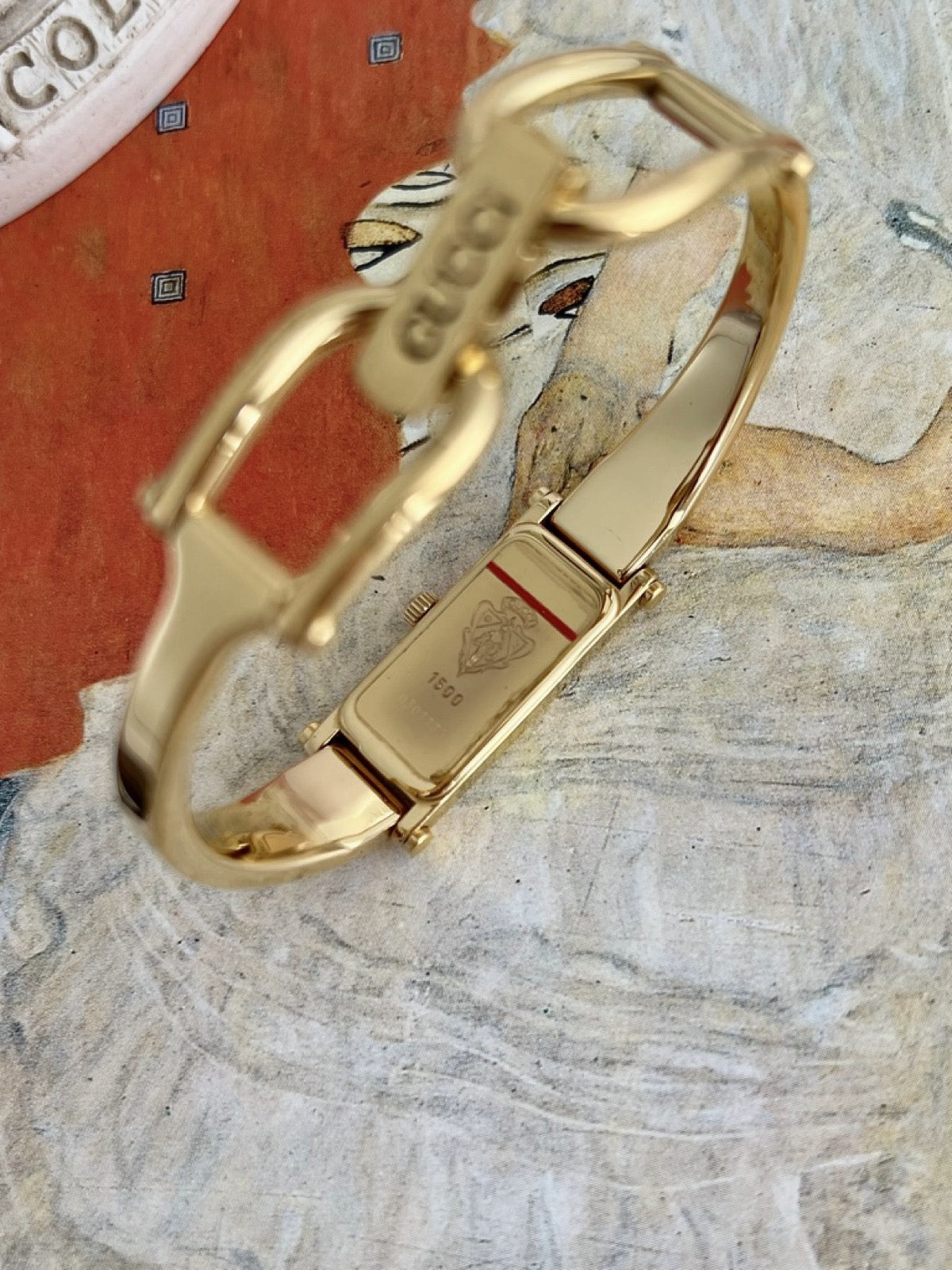 Gucci 1500 gold tone women’s watch caseback showing the engraved Gucci crest and model reference