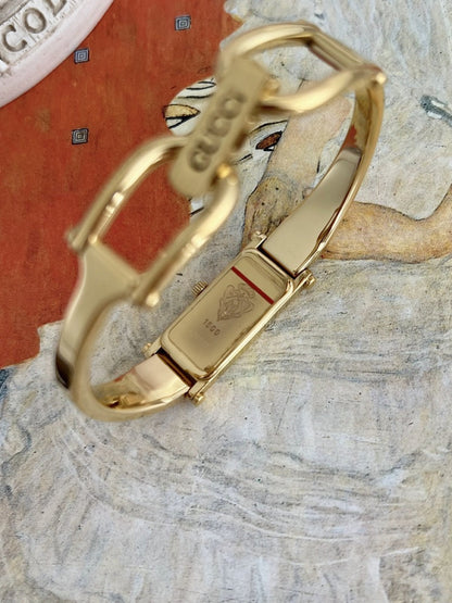 Gucci 1500 gold tone women’s watch caseback showing the engraved Gucci crest and model reference
