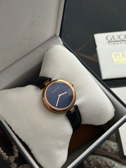 Gucci Diamantissima watch showing its two hands, marker free dial and polished round rose gold tone case.