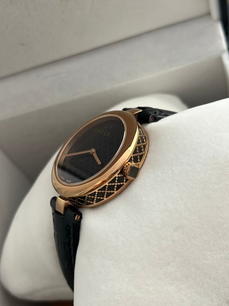 Opposite side view of the Gucci Diamantissima patterned case and black leather strap attachments.