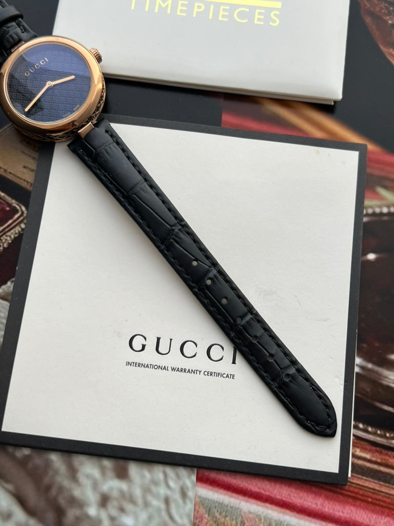Gucci Diamantissima women’s watch showing the black leather strap texture, stitching and adjustment holes.