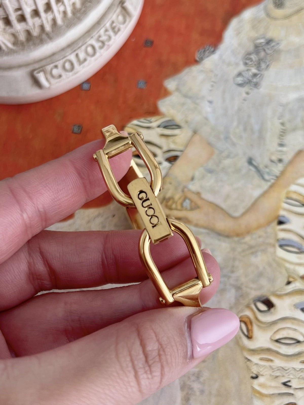 Gucci signed gold tone horsebit folding clasp with black lettering on the women’s bangle watch