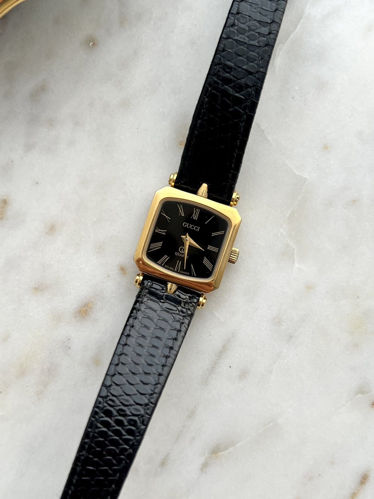 Front dial detail of Gucci Sherry black Roman dial square gold tone women’s watch