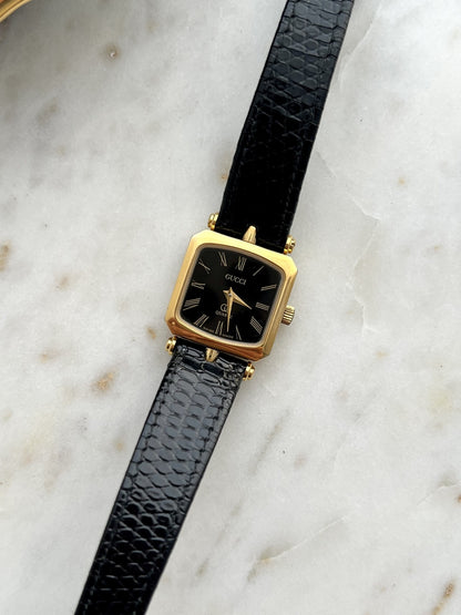 Front dial detail of Gucci Sherry black Roman dial square gold tone women’s watch
