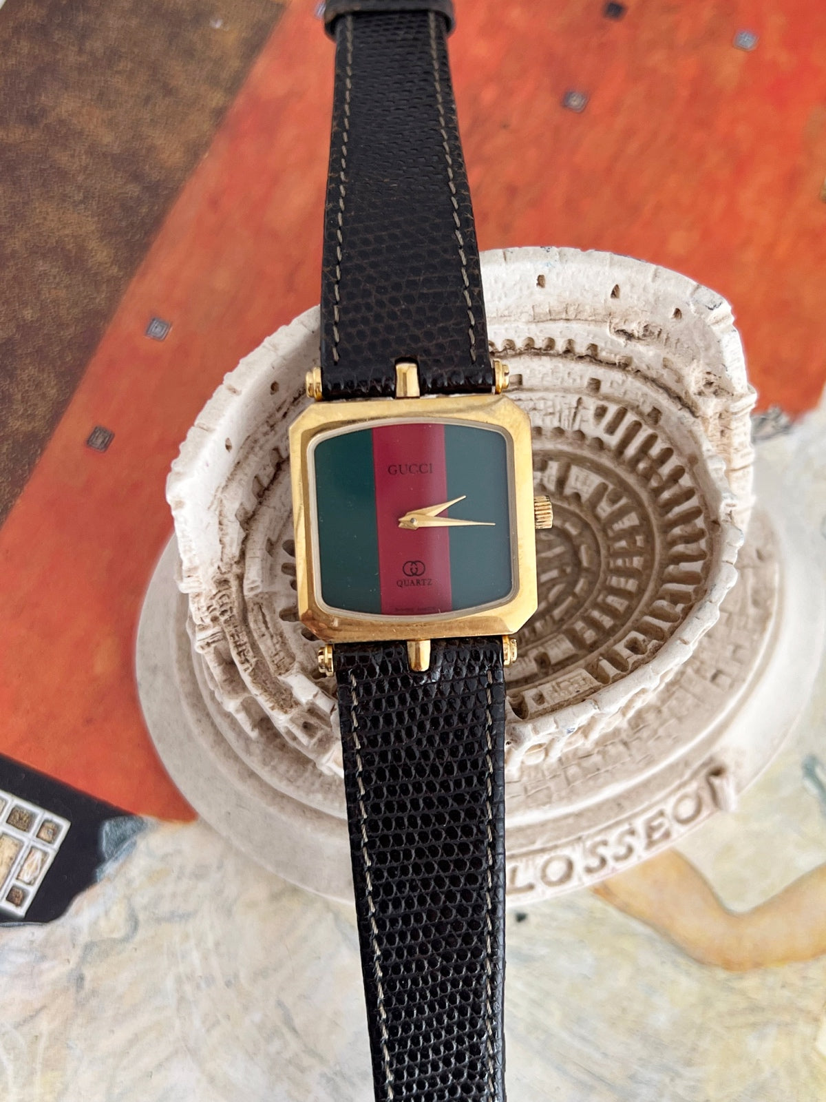 Front detail of the Gucci Sherry women’s watch showing the green dial, red centre stripe, gold tone hands and square case.