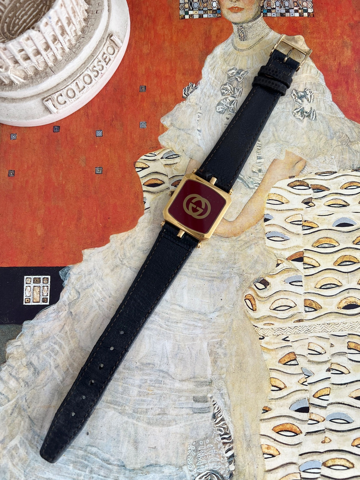 Reverse of the Gucci Sherry women’s watch showing the red caseback with gold GG emblem and black leather strap.
