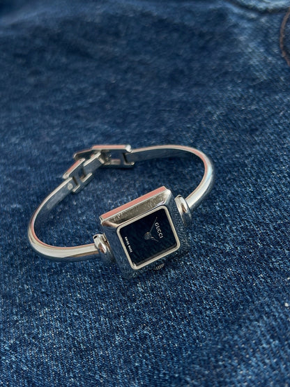 Side view of the Gucci women’s square steel watch showing the curved bangle and clasp