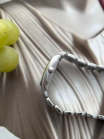 Side profile of the Hamilton Bagley stainless steel case, signed fluted crown and curved bracelet links.