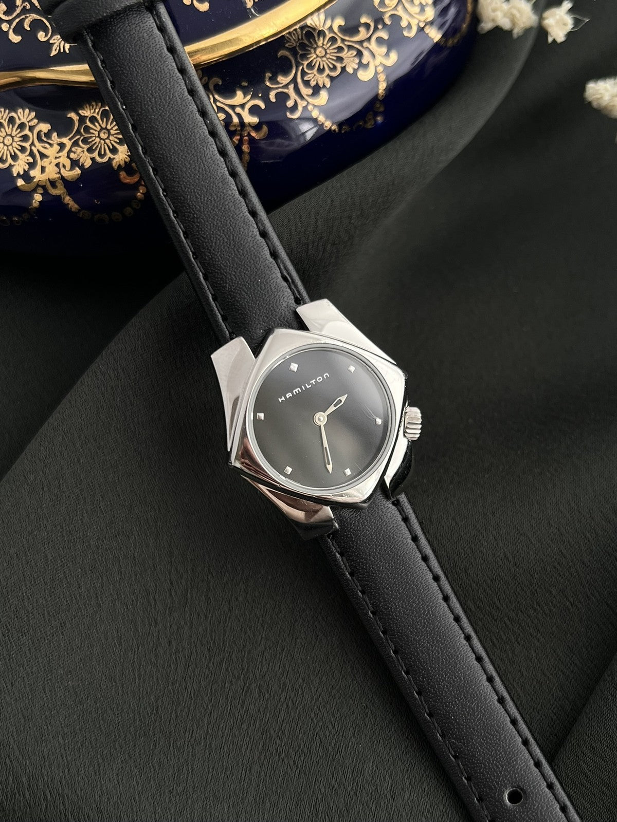 Close view of the Hamilton Stardom 6357 black dial with applied square markers and openworked hands