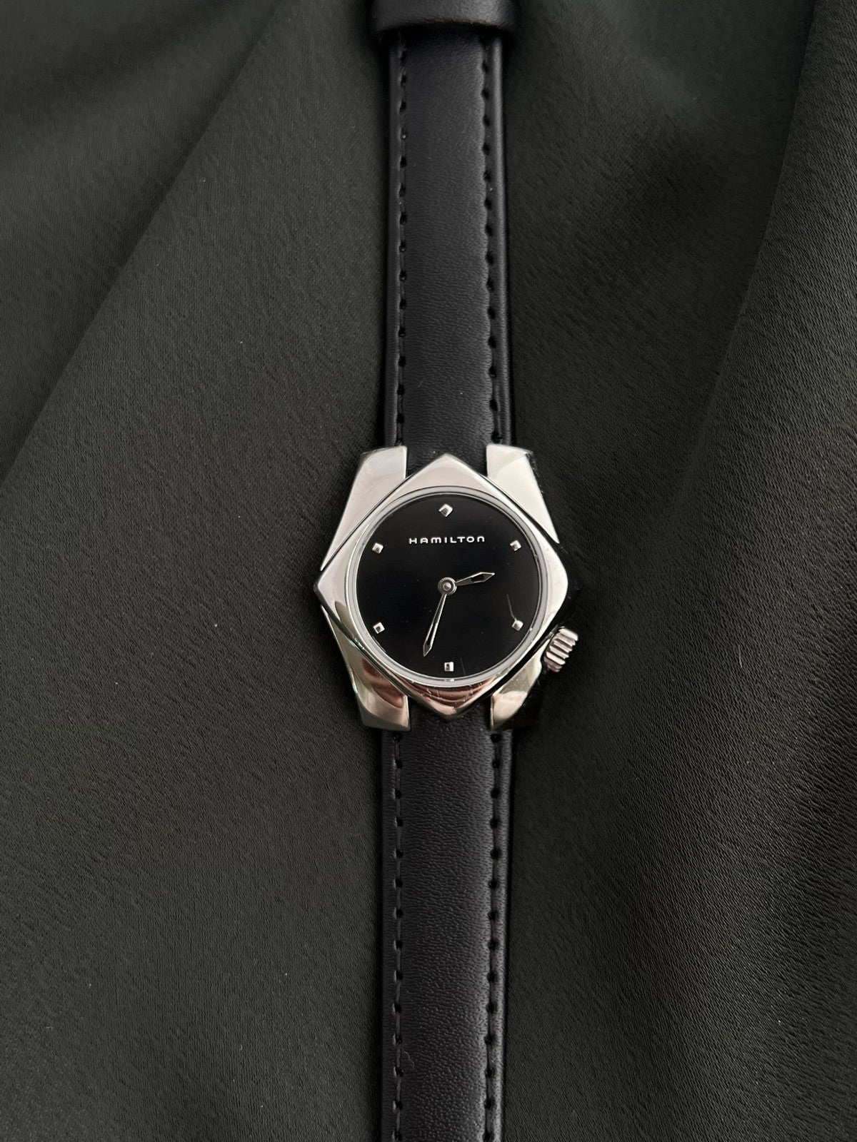 Straight-on Hamilton Stardom 6357 watch showing the black dial, geometric case and black leather strap