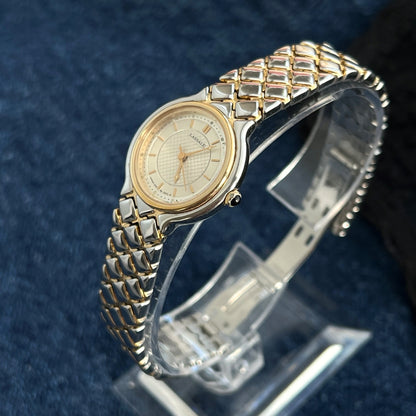Side view of the Lassale by Seiko two tone watch with its dark stone crown and folding bracelet