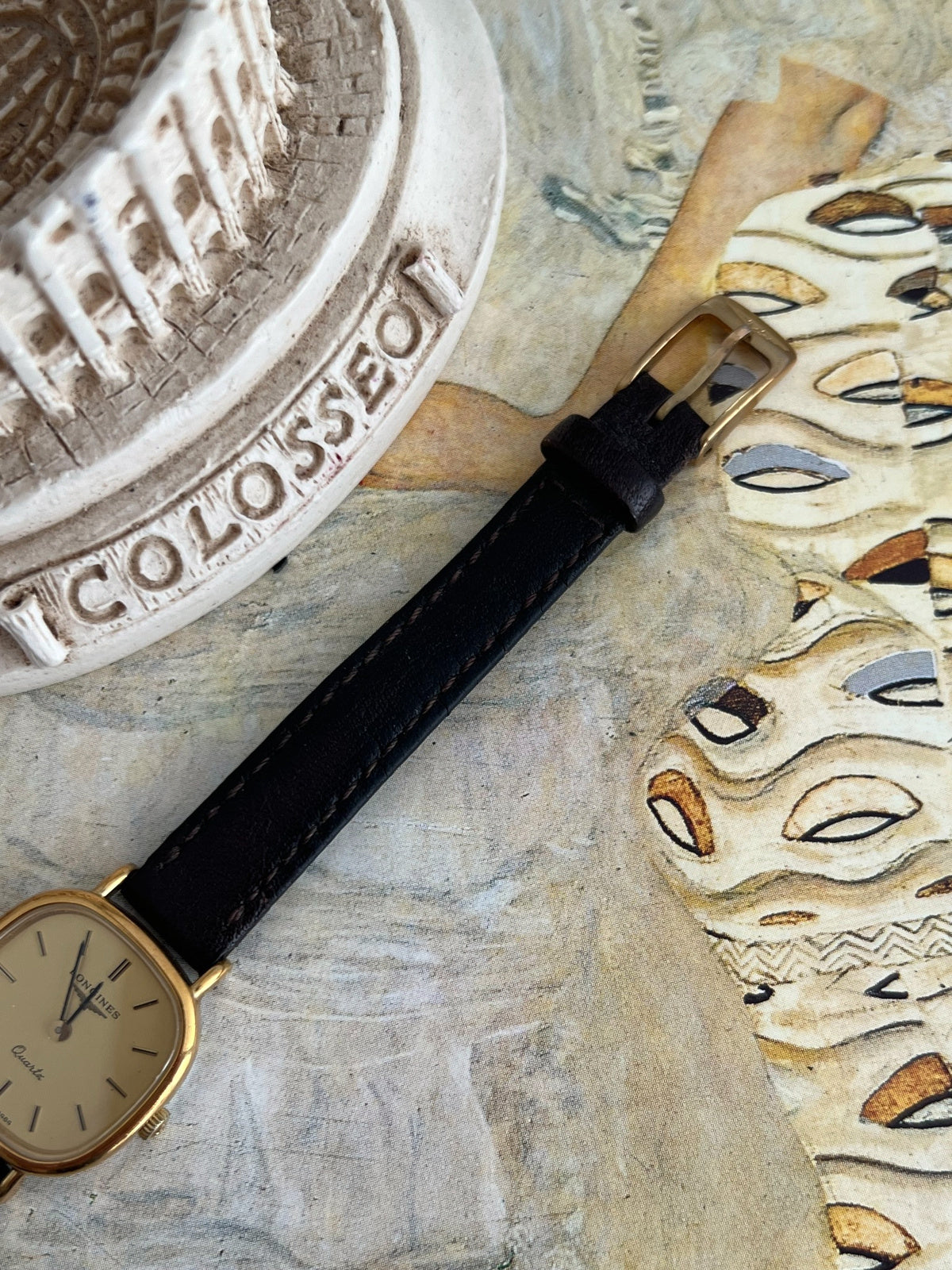 Gold tone pin buckle and black leather strap on the Longines champagne dial watch