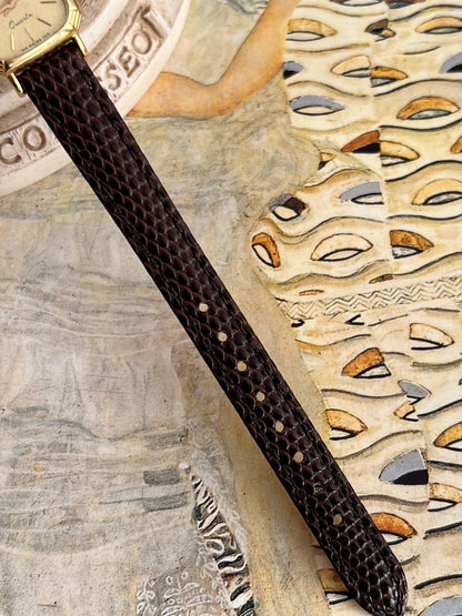 Brown Hirsch leather strap showing raised scale pattern, stitching and adjustment holes.
