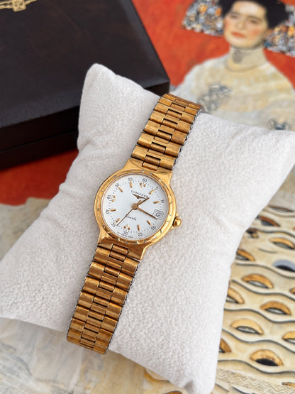 Angled detail of the Longines Conquest white dial, gold tone scalloped bezel and integrated gold bracelet.