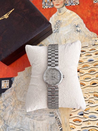 Longines Conquest women's watch with silver grey dial and integrated silver tone bracelet on a white cushion.