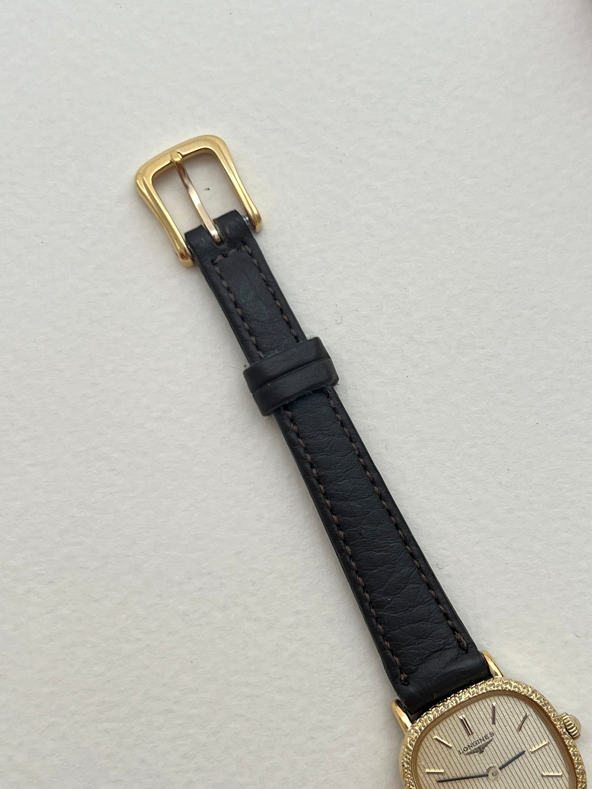 Close-up of the Longines striped champagne dial, blackened hands and gold hour markers.