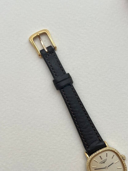 Close-up of the Longines striped champagne dial, blackened hands and gold hour markers.
