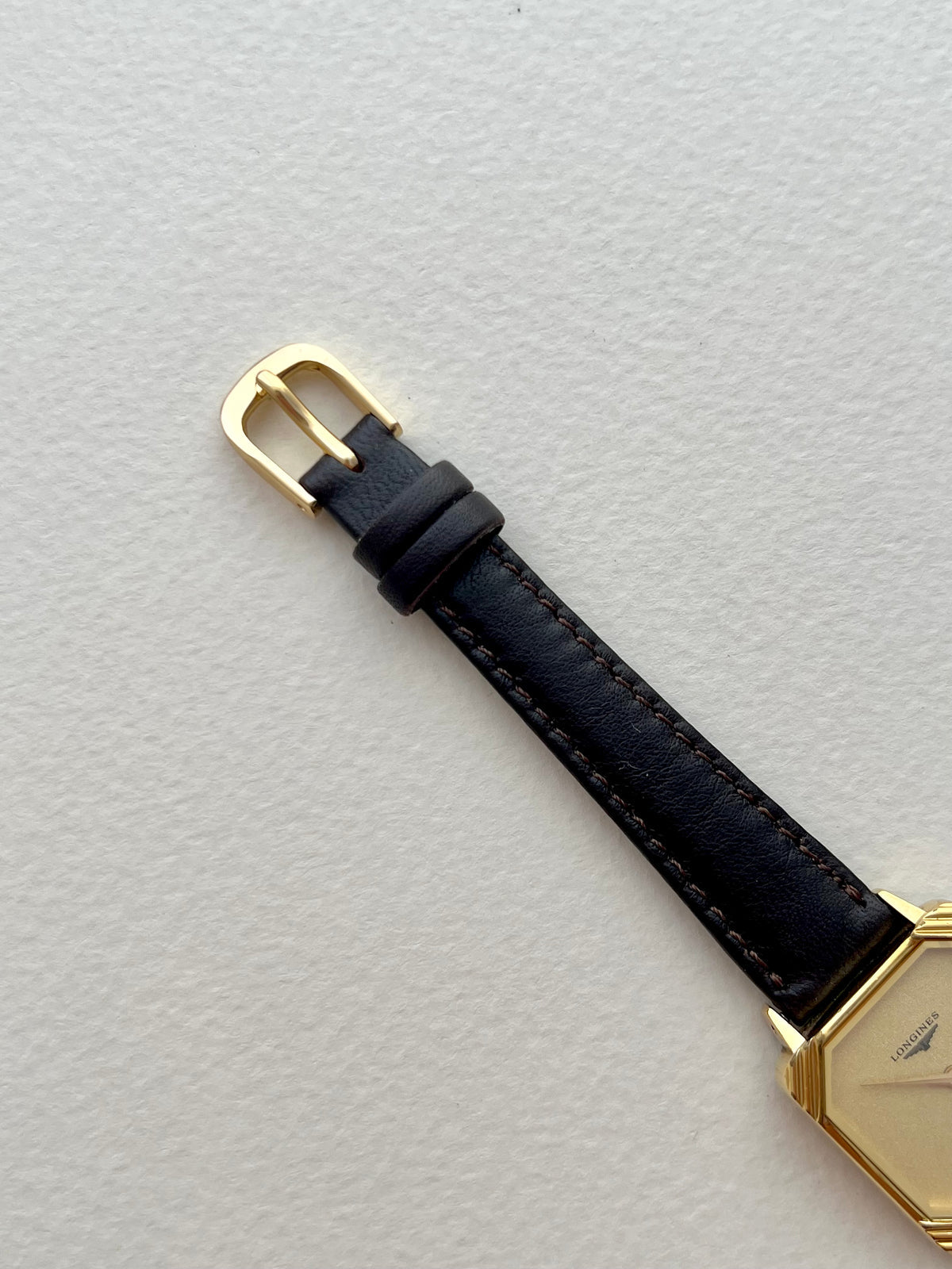 Detailed view of the clean champagne dial, gold hands and Longines branding.