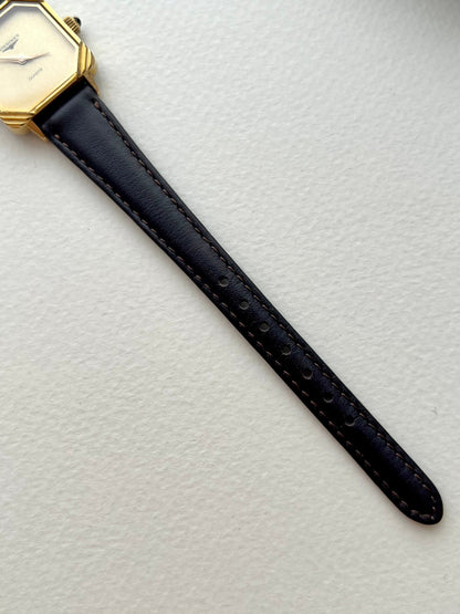 Side angle showing the sculpted gold-tone corner frame and square case of the Longines watch.