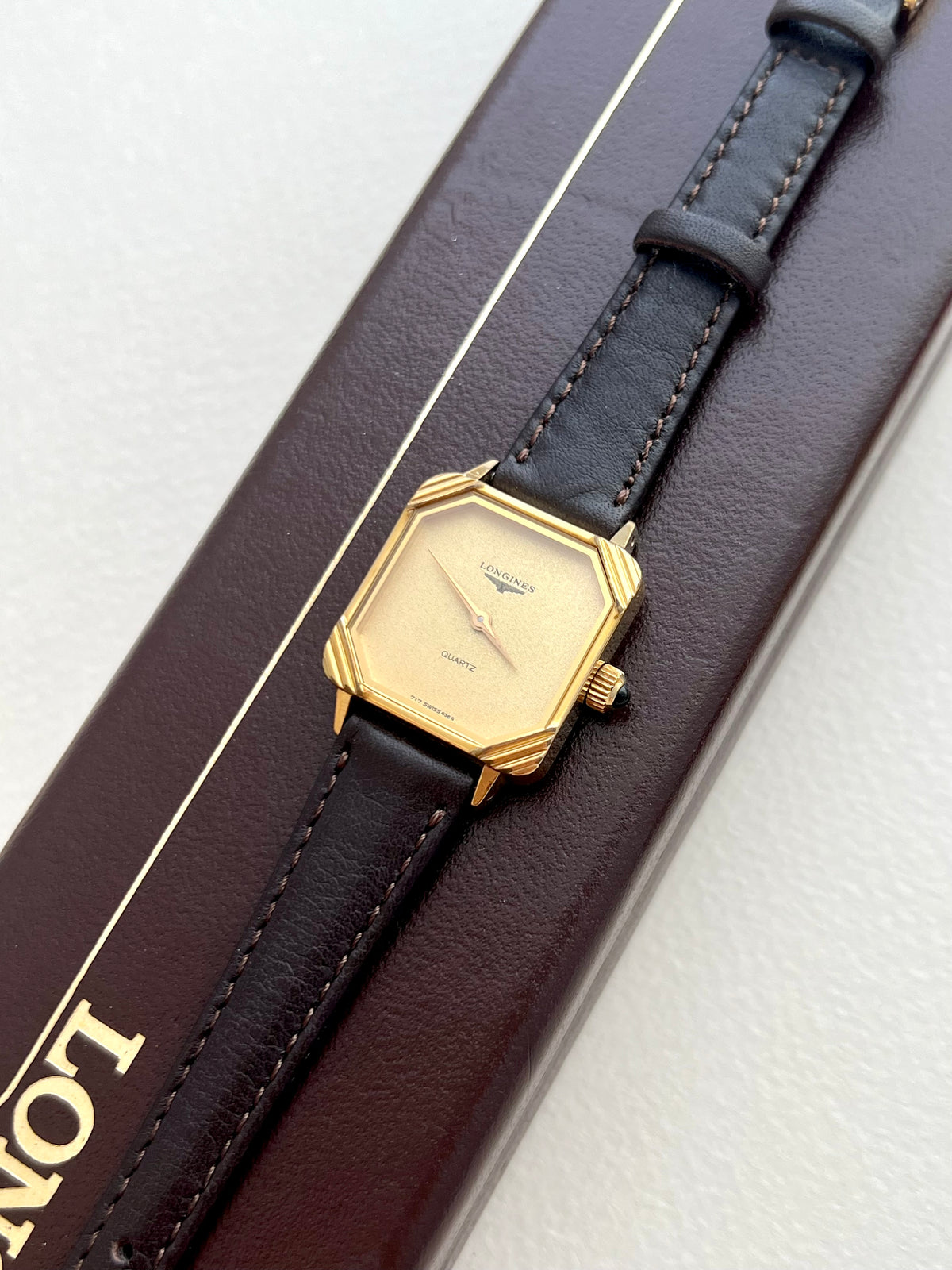 Side profile of the Longines Decorated Corner watch case and black cabochon crown.