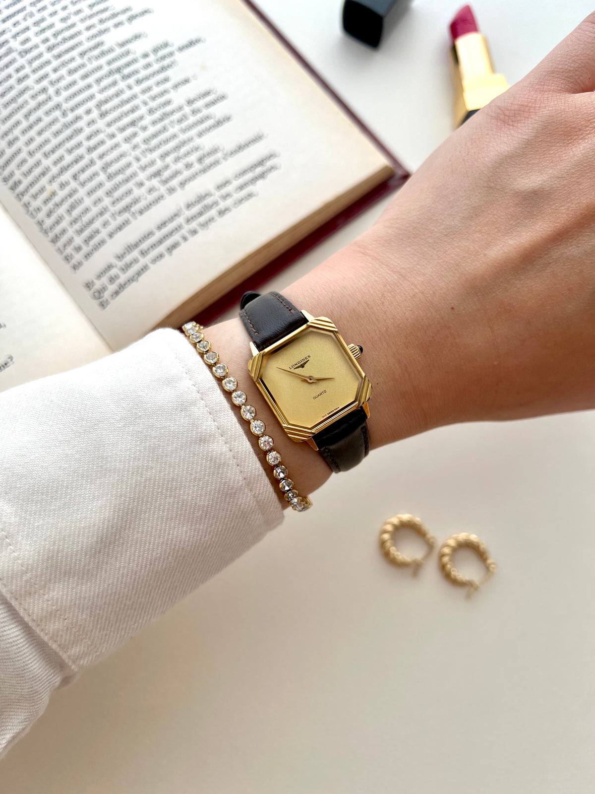 Close-up of the minimalist champagne dial and Longines logo inside the sculpted gold frame.