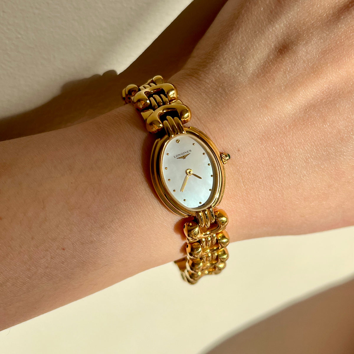Longines Equestrian L6.132.2 pale dial gold-tone horseshoe bracelet watch worn on the wrist