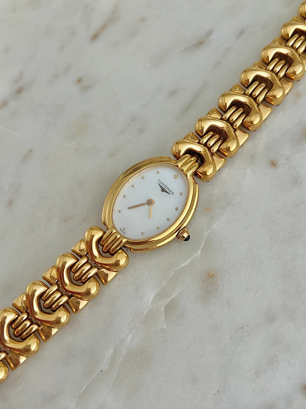 Front view of the Longines Equestrian L6.132.2 watch with oval dial and gold horseshoe bracelet