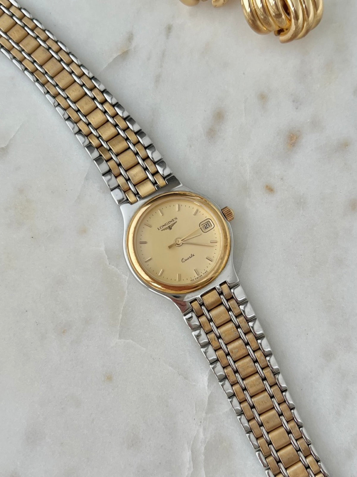 Angled detail of the Longines Flagship dial, gold tone bezel and two tone bracelet