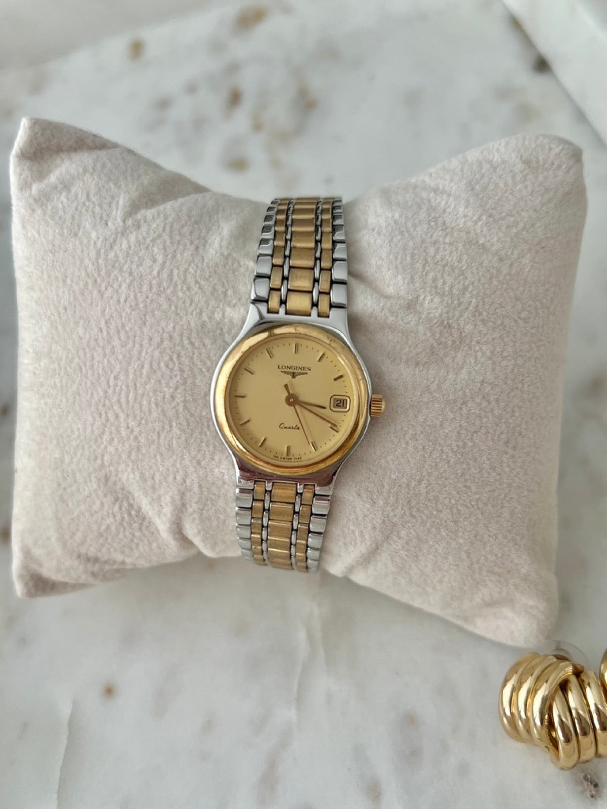 Straight on view of the Longines Flagship champagne dial with gold tone markers and date