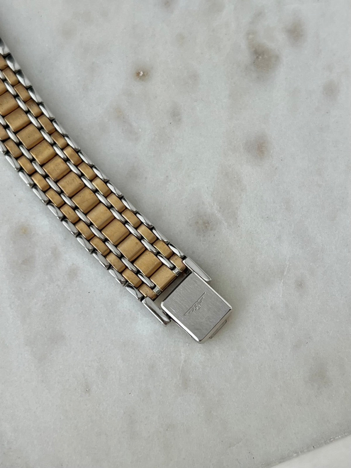Close detail of the Longines Flagship bracelet clasp and gold tone centre links