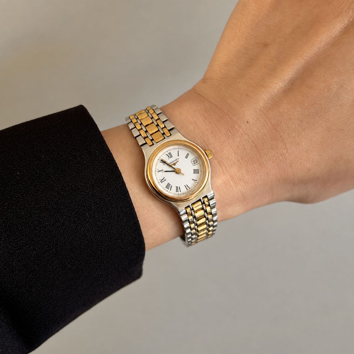 Longines Flagship two tone Roman numeral date watch on wrist with a subtle golden hour glow