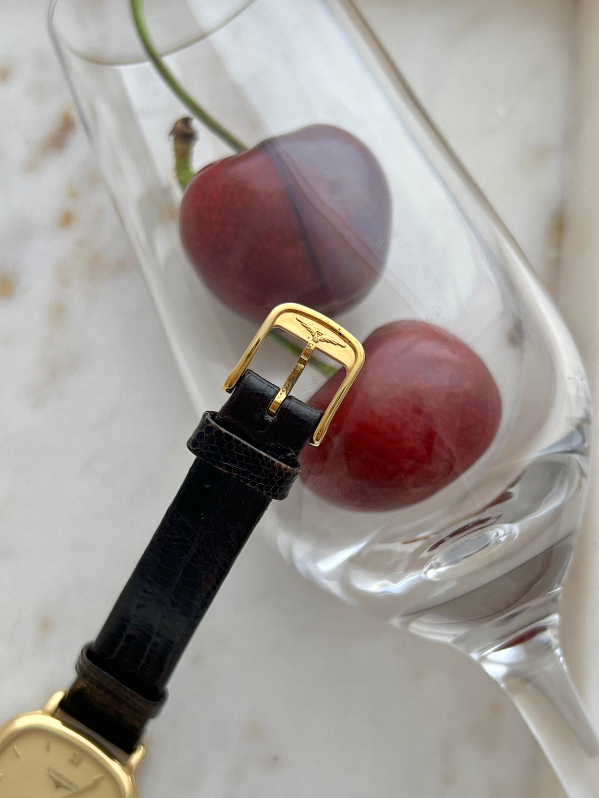 Longines Cushion Champagne Stripe Women’s Watch — Closer view of the signed buckle supported on a glass