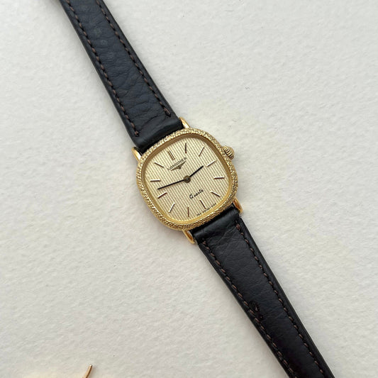 Caseback view of the Longines gold cushion watch with textured bezel and black aftermarket leather strap.