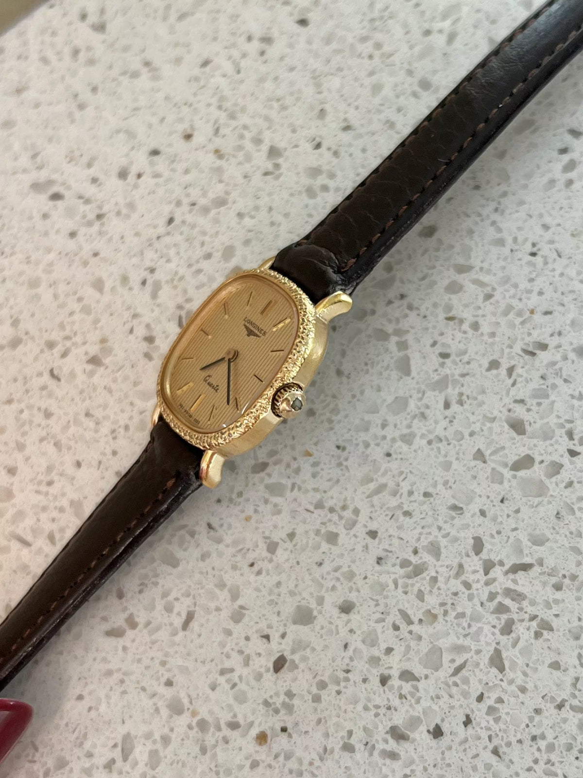 Longines gold cushion ladies watch shown with its presentation box.