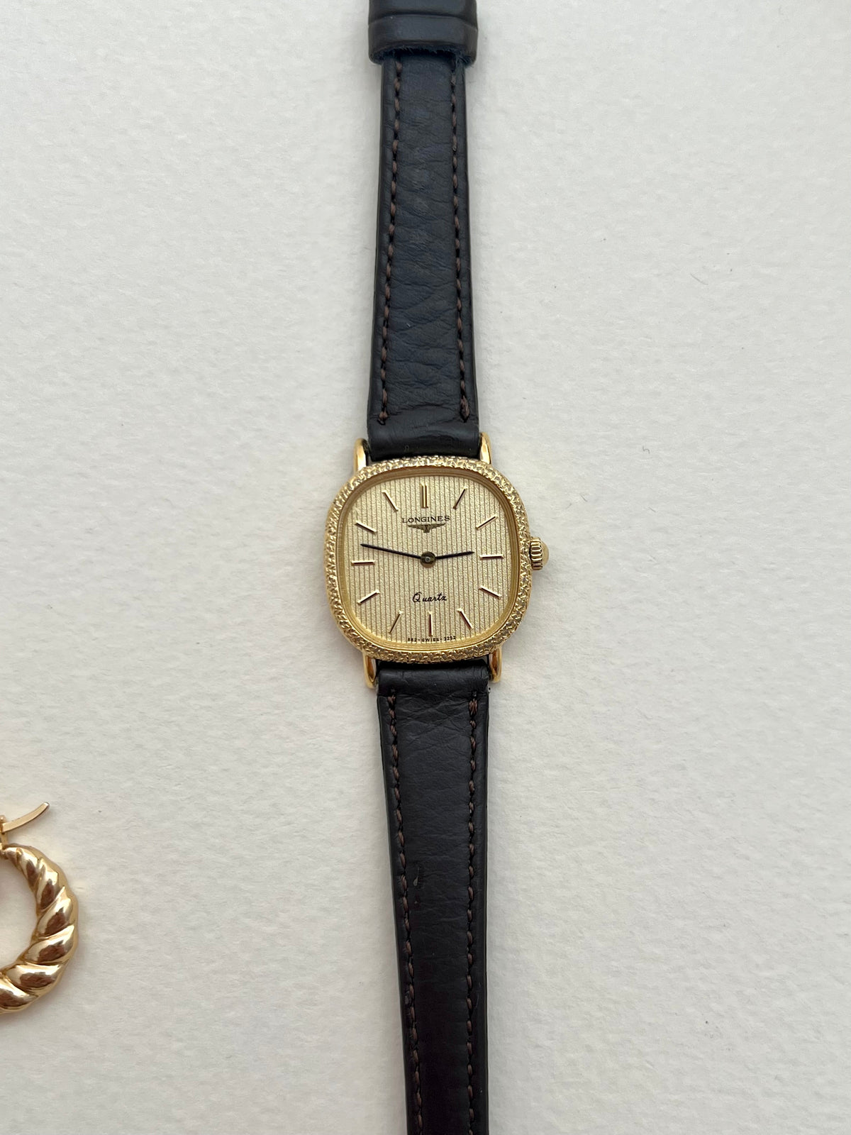 Close-up caseback detail of the vintage Longines gold cushion watch.