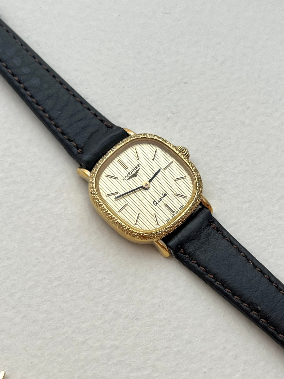 Close-up of the Longines cushion watch caseback and gold-tone case.