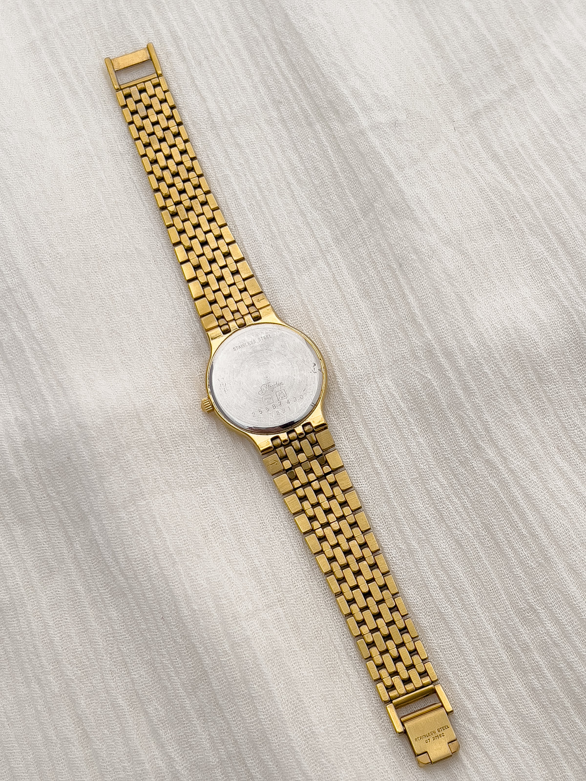 Gold-tone Longines watch with a subtle geometric dial pattern and date display.