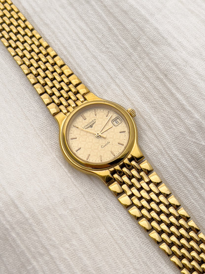 Vintage Longines bracelet watch with textured dial and gold-tone hands.