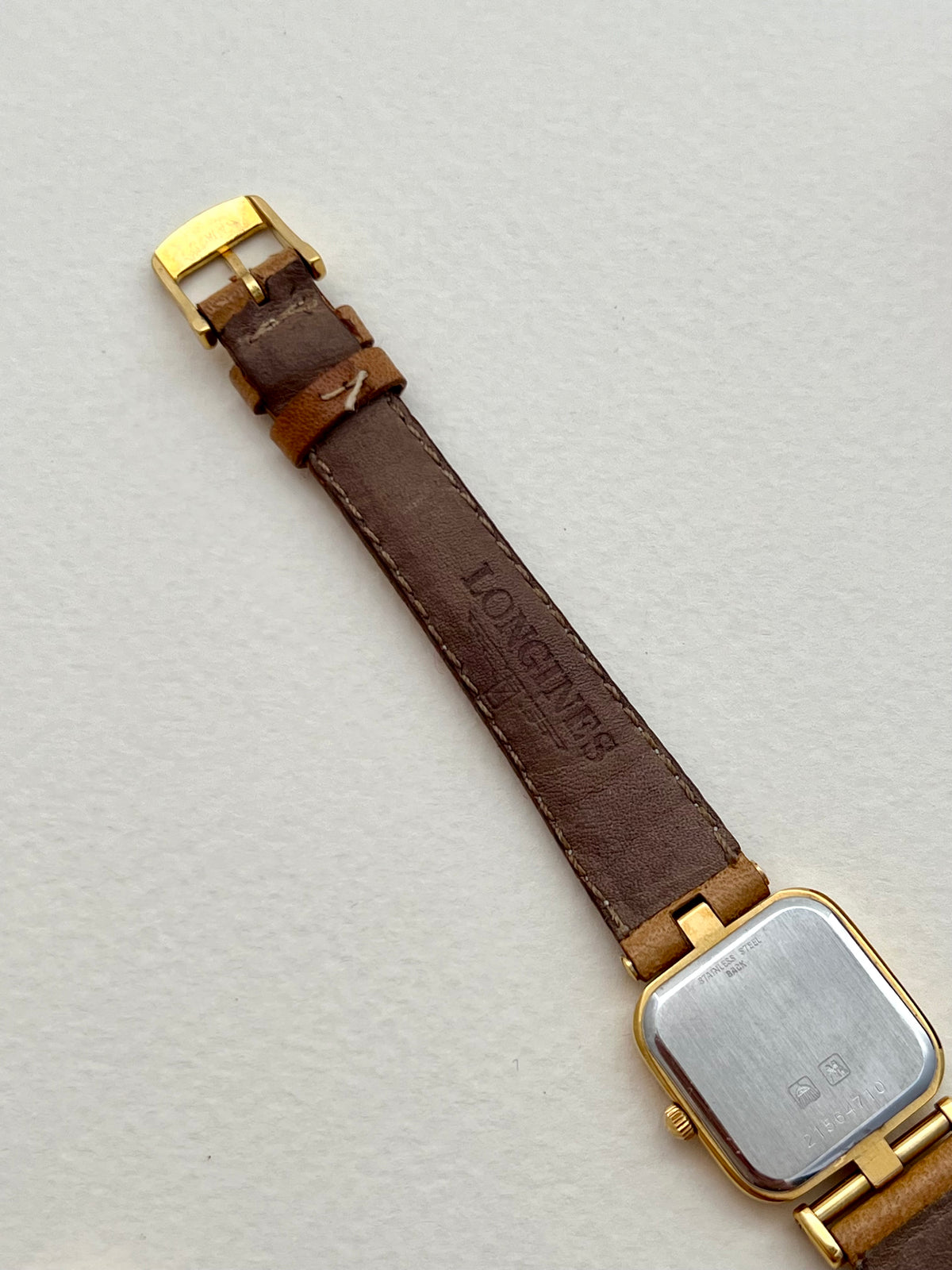 Longines gold watch displayed with its original box.