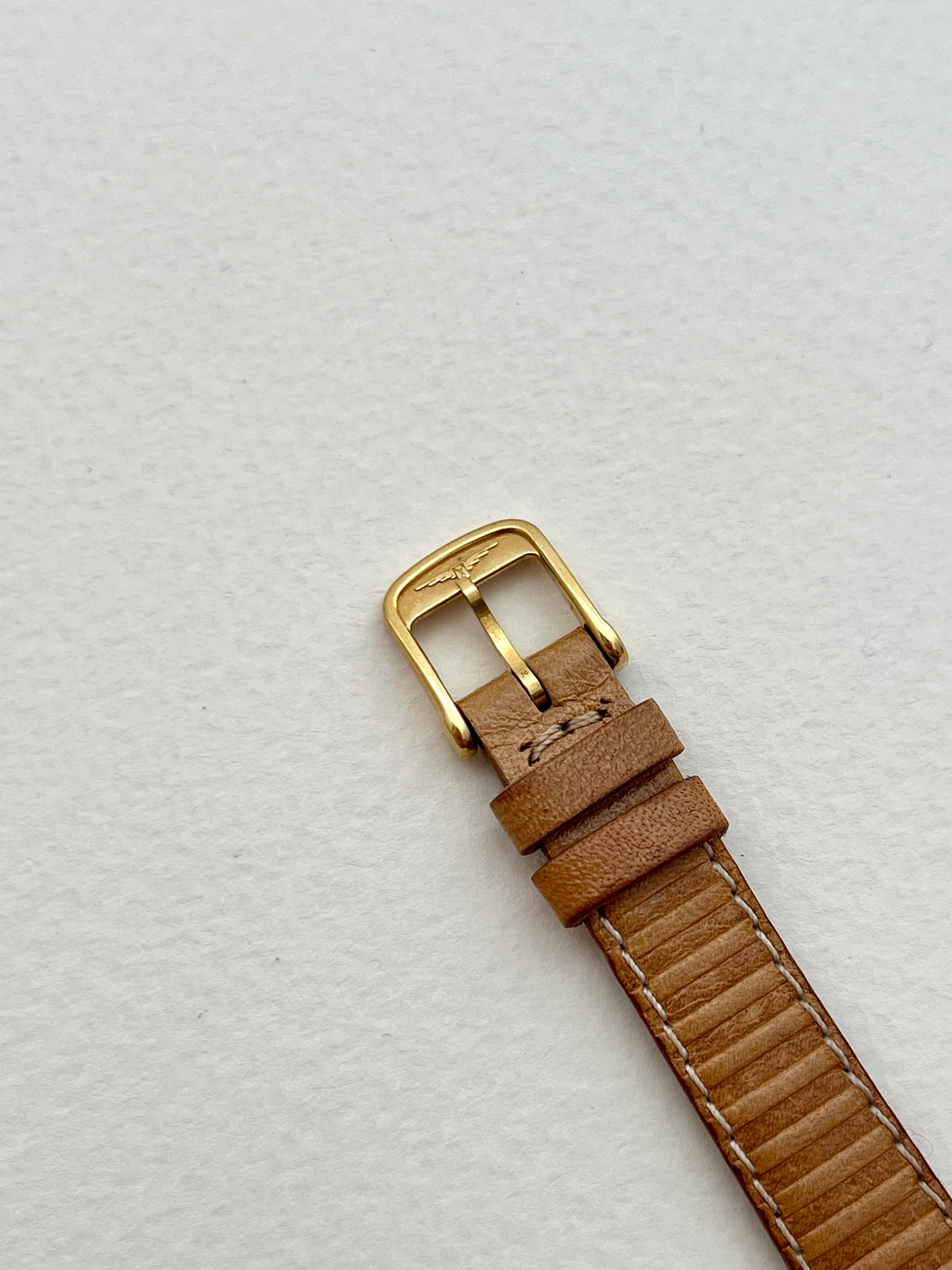 Side profile of the Longines gold-tone case and asymmetrical strap lugs.