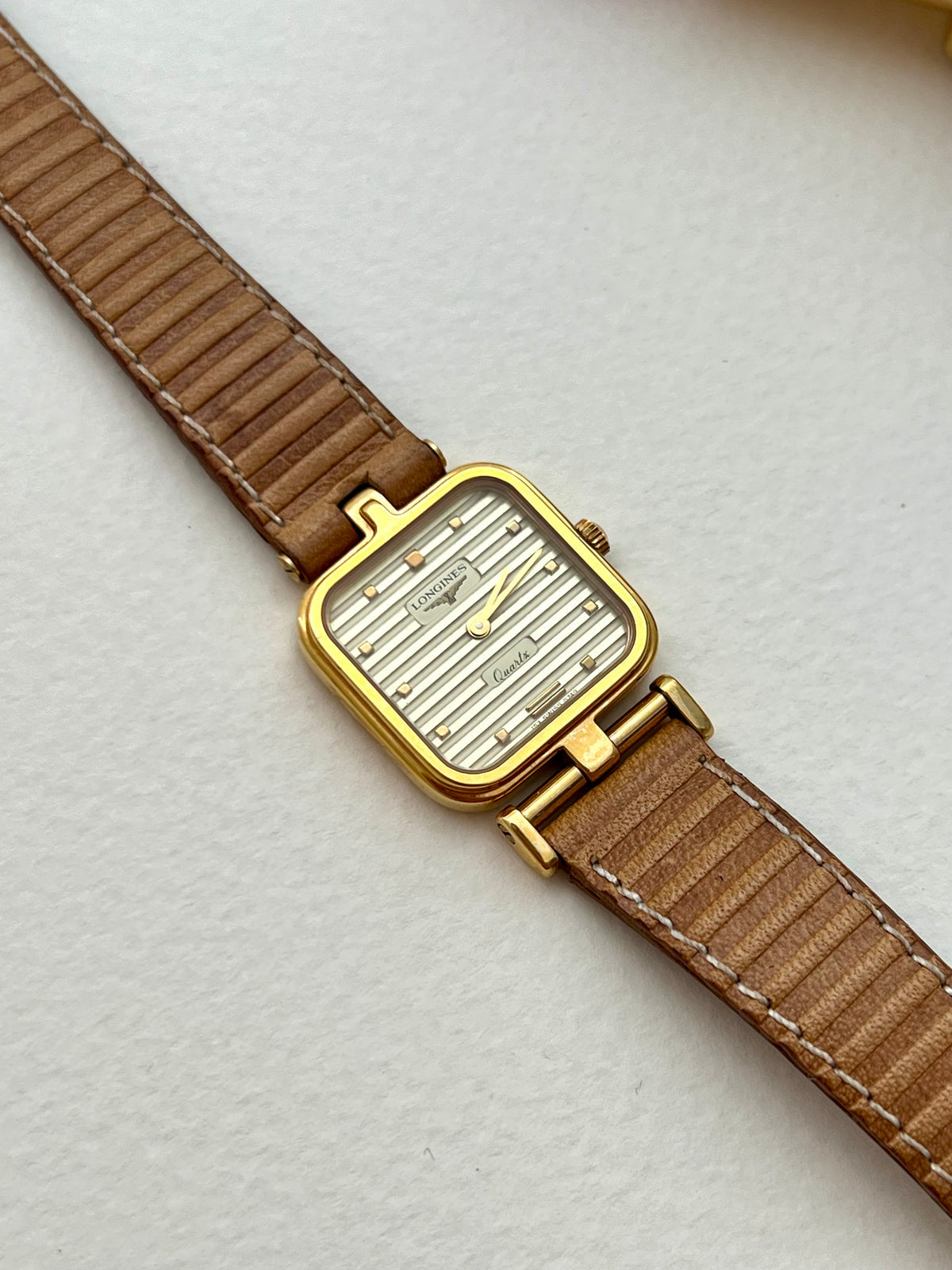 Front view of the Longines warm-gold square-cushion watch with ridged dial.