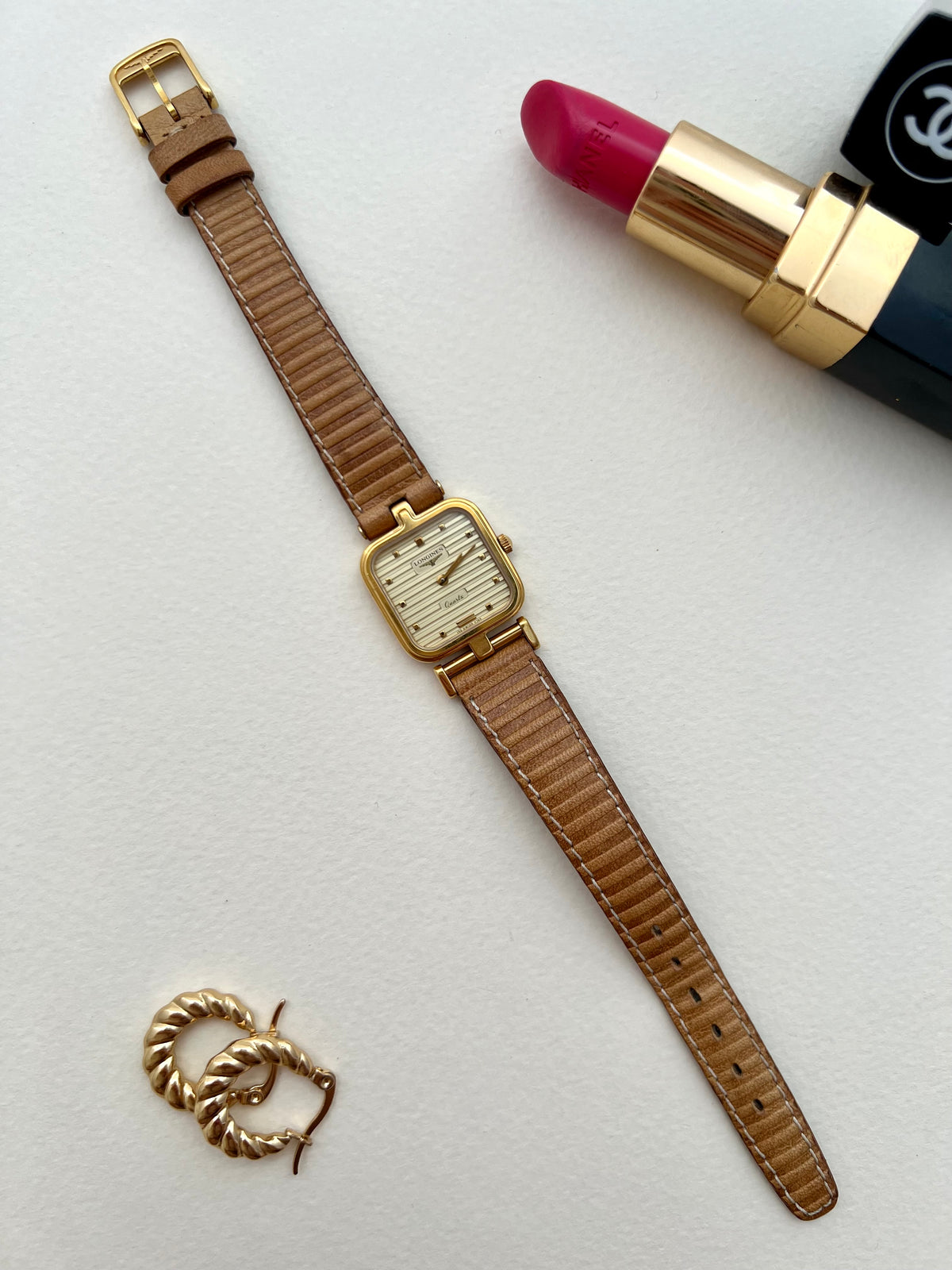 Longines gold square-cushion watch shown on a wrist.
