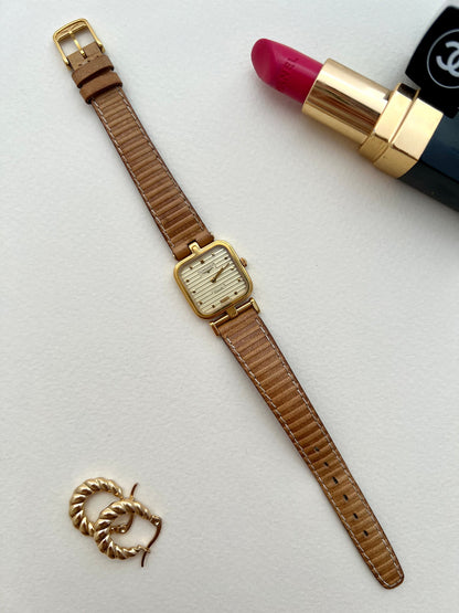 Longines gold square-cushion watch shown on a wrist.