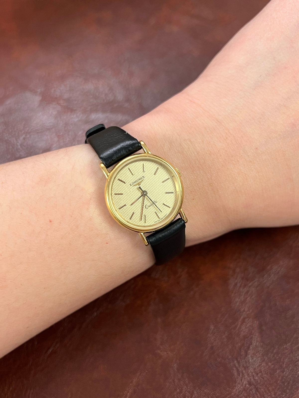 Longines Striped Gold Dial Leather Strap Women’s Watch, worn on the wrist.